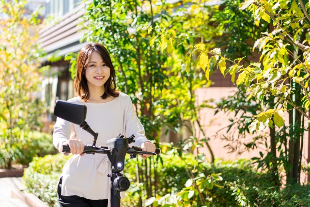 電動キックボードに乗る女性